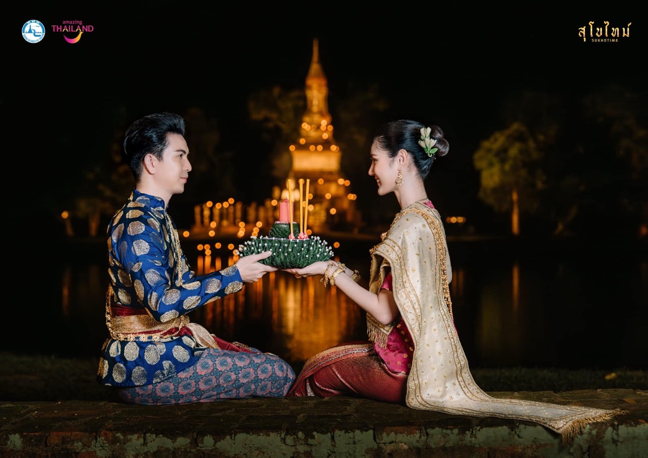 Loy Krathong candles and offerings floating on the ancient moat at Sukhothai Historical Park