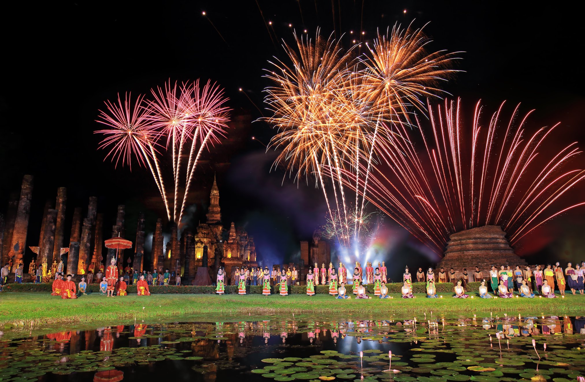 Loy Krathong festival at the Sukhothai Historical Park — candlelit krathong floating on the ancient moat at night