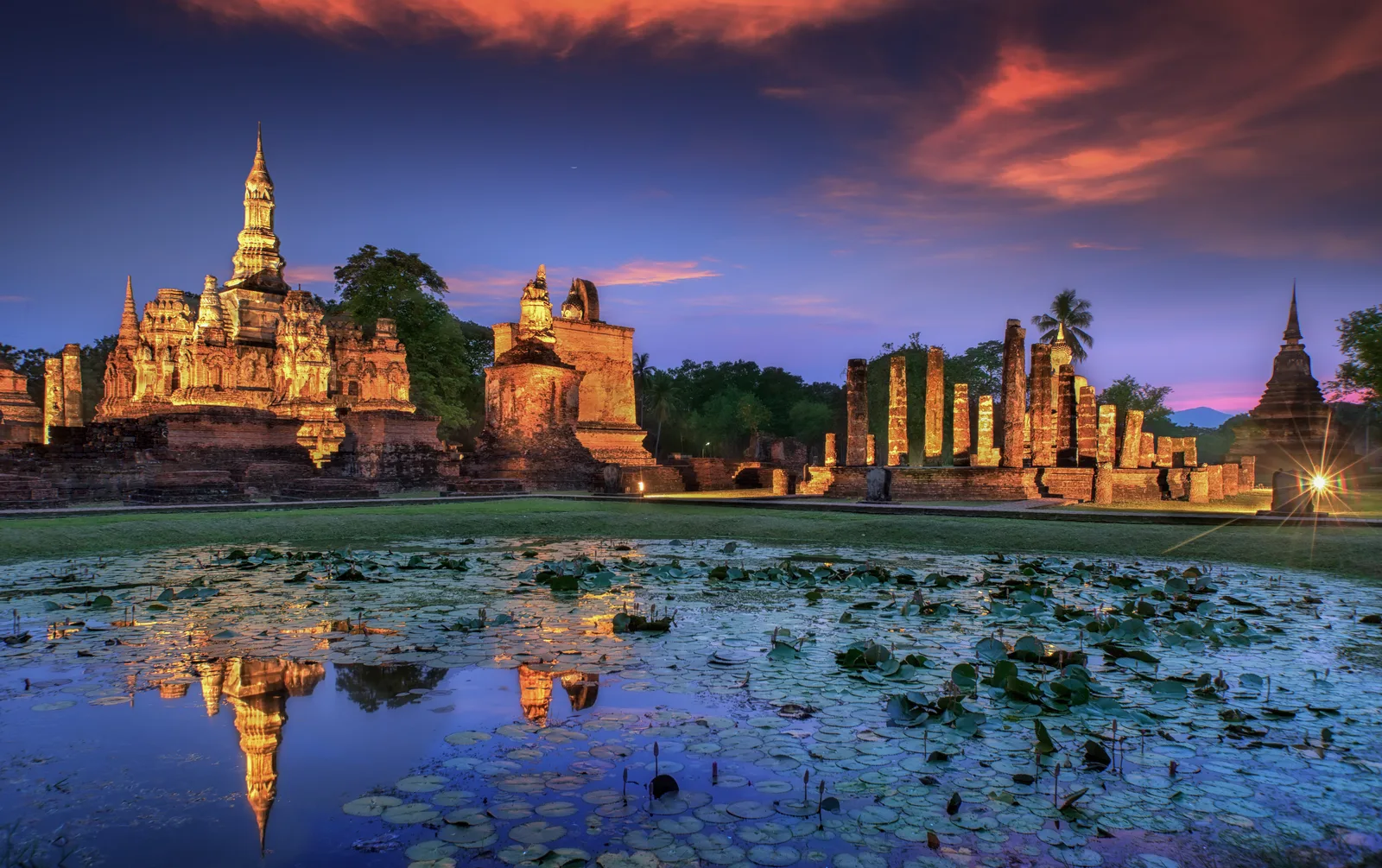 Morning mist drifting across the lotus moat surrounding Wat Mahathat, Sukhothai Historical Park