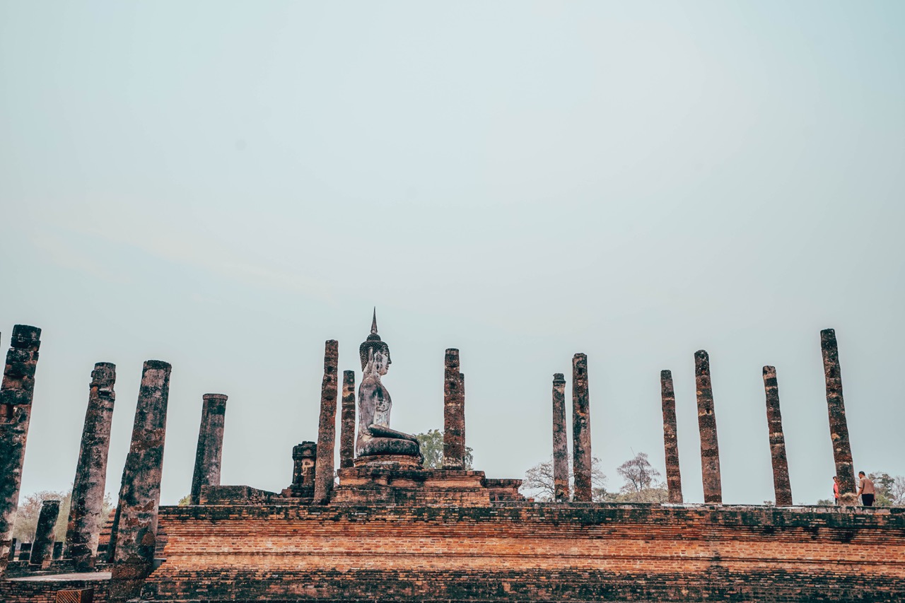 Sukhothai Historical Park at sunrise — stone temples rising above lotus-filled moats in morning mist