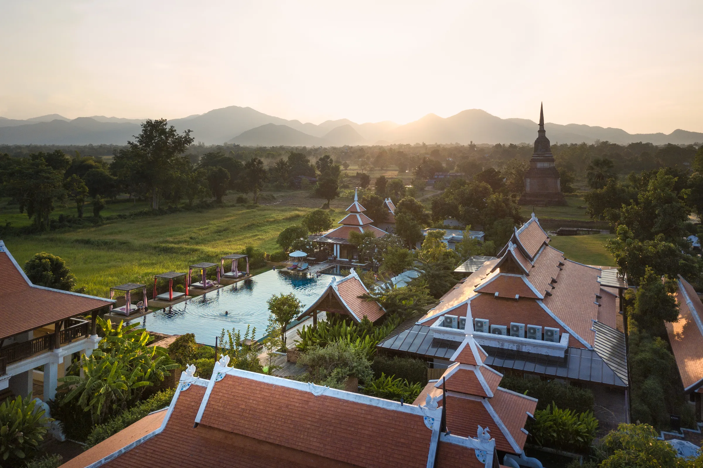 Aerial view of Sukhothai Historical Park and surrounding landscape at golden hour